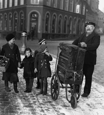 Kinderen bij een klein draaiorgeltje rond 1900